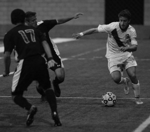 Hugging the line: Junior defender and co-captain Tal Zaiet maneuvering around opposing players. Photo by Andrea Whistler - Staff Photographer