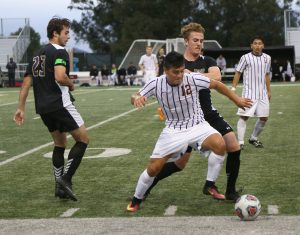 Maintaining control: Jaime Alvarado defends the ball against two Whittier players at Saturday night’s game.  Photo Credit--Ashleigh Coulter Staff Photographer