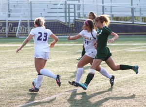 Running past: Julia Kearns and Maddy Griess take the ball and run past La Verne defenders to gain ground for the Regals. Photo Credit--Kaelani Medina Staff Photographer