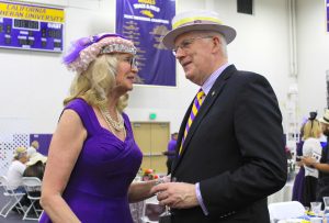 Kim Overton (L) and John Larisey (R) share a conversation by the silent auction tables at the seventh annual Hats and High Tea event intended to raise money for scholarships on March 12 in Gilbert Arena.  Photos by Amanda Souza- Staff Photographer 